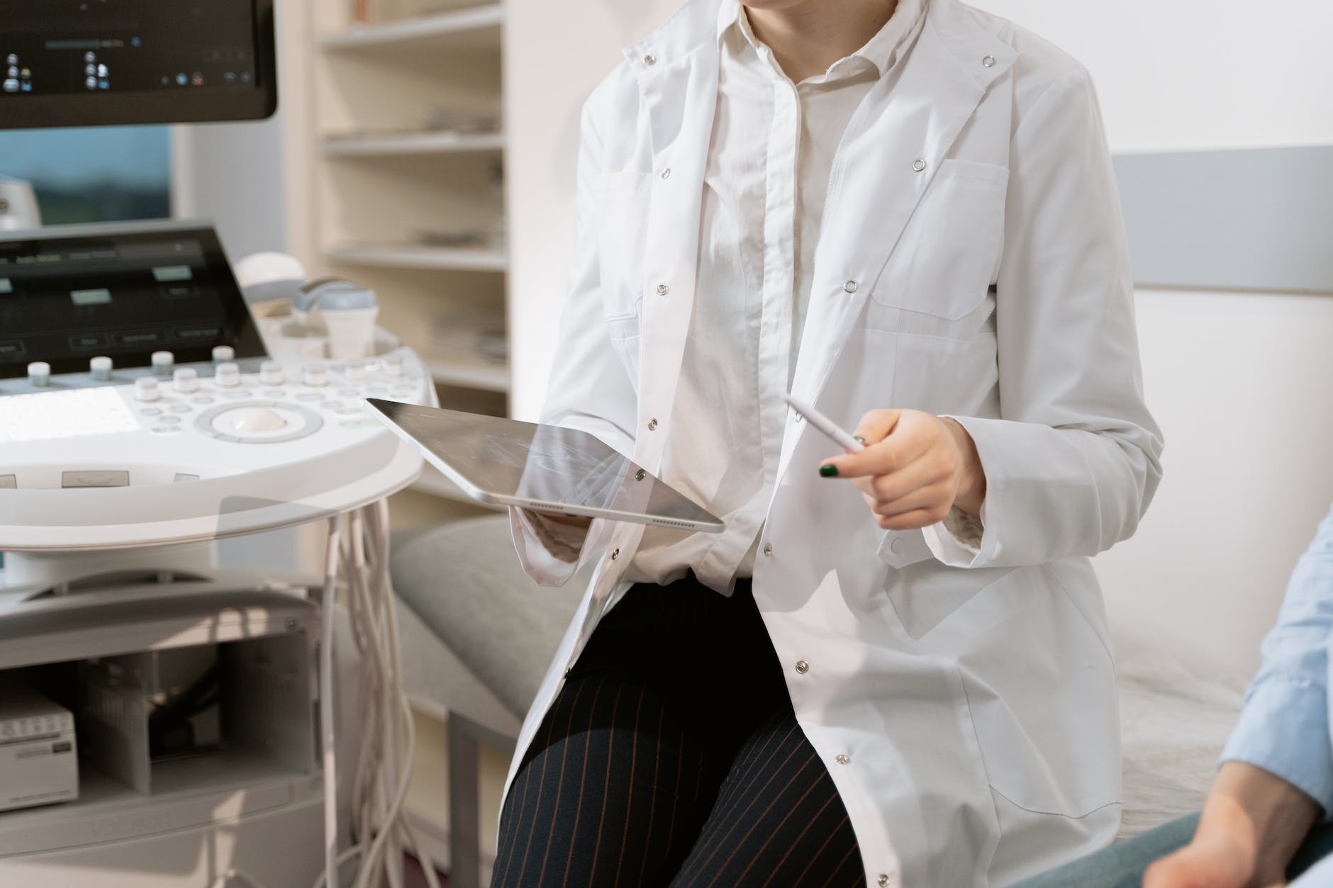 photo of gynecologist sitting near medical equipment